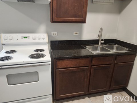 A kitchen with a white stove and brown cabinets.