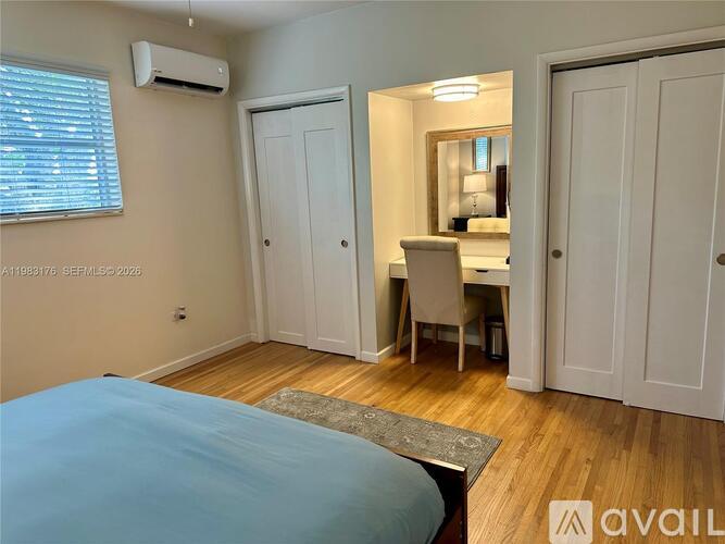A bedroom with a bed, desk, and chair.