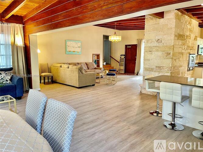 A living room with a sofa, chairs, and a dining table.