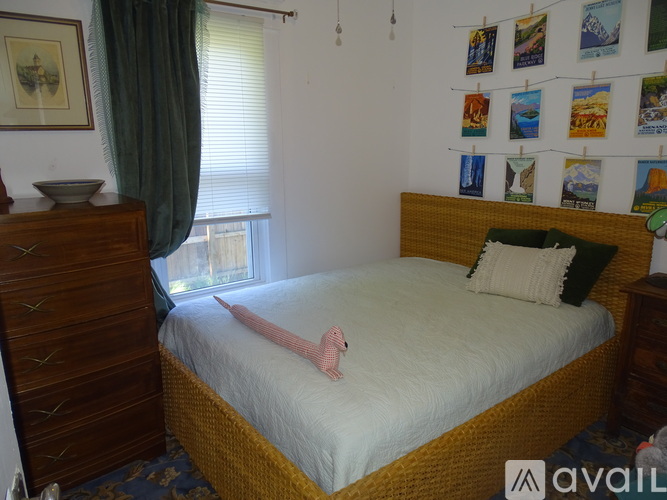 A bedroom with a bed, a dresser, and pictures on the wall.