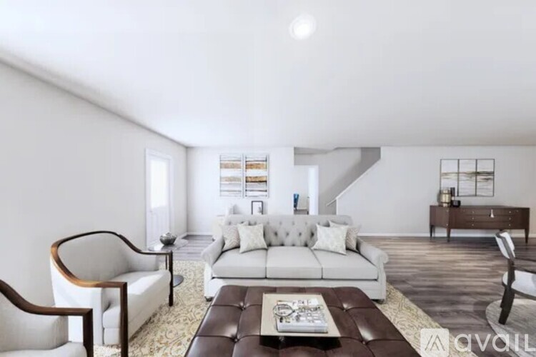 A living room with a white couch and a brown coffee table.