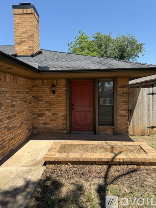 A house with a red door and a brick wall.