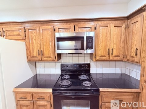 A kitchen with wooden cabinets and a black stove top.