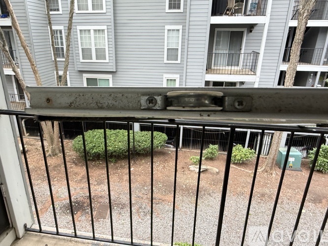 A metal gate is in the foreground of a photo showing a view of apartment buildings.