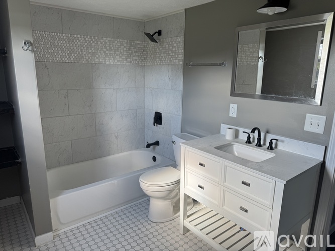 A white toilet sits in a bathroom next to a bathtub.