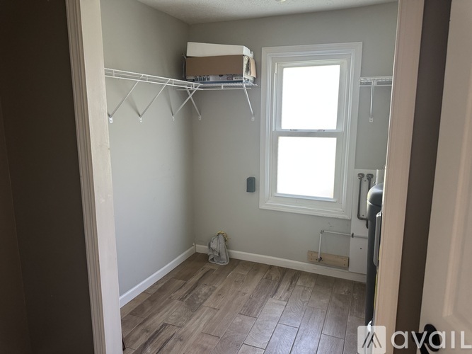 A room with a window and a white shelf above it.