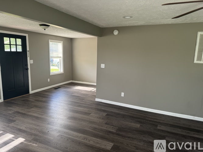 A room with a black door and a window with a white frame.