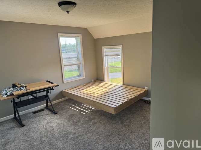 A room with a bed, desk, and window.