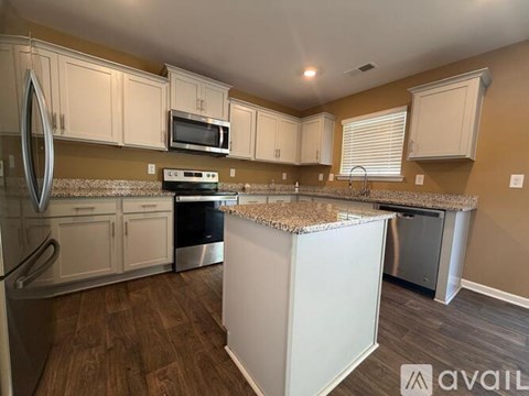 A kitchen with white cabinets and a granite countertop.