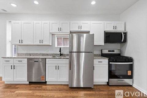 A kitchen with white cabinets and stainless steel appliances.