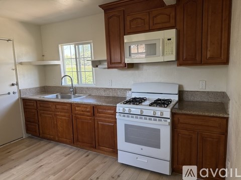 A kitchen with a white stove and wooden cabinets.