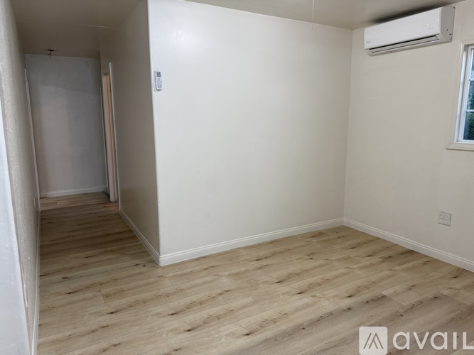 A room with wooden flooring and a window.