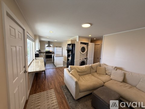 A living room with a white couch and a rug.