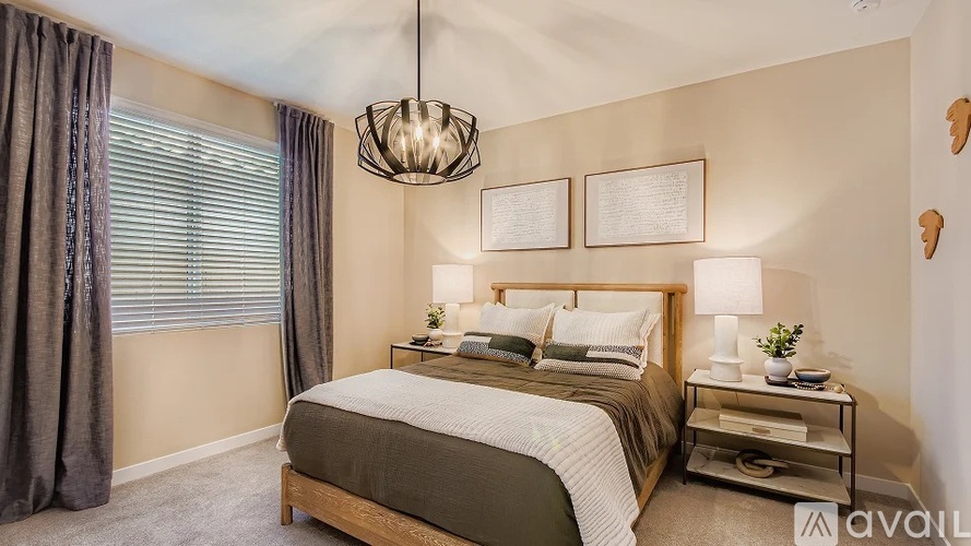 A bedroom with a large bed and a chandelier.