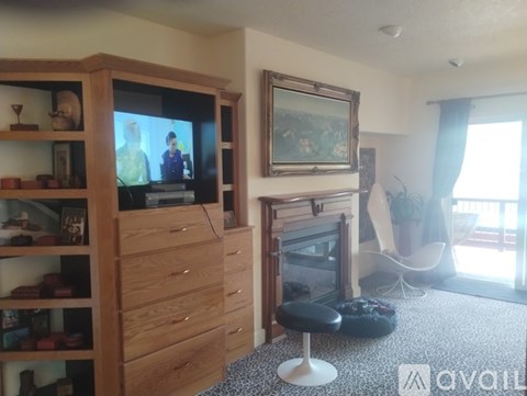 A living room with a television, a chair, and a painting on the wall.