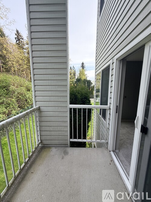 A balcony with a metal railing and a view of trees.