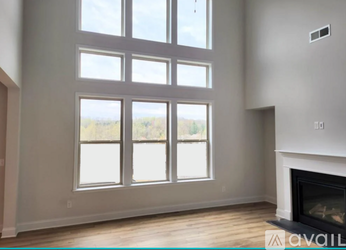 A living room with a fireplace and large windows.