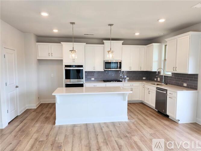A modern kitchen with white cabinets and a central island.