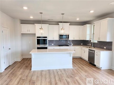 A modern kitchen with white cabinets and a central island.