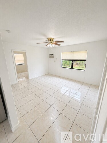 A room with a ceiling fan and tiled flooring.