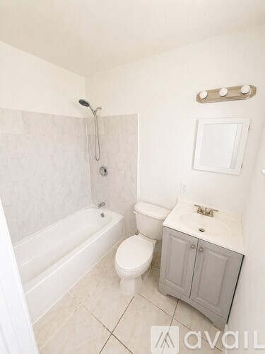 A white bathroom with a toilet, sink, and bathtub.