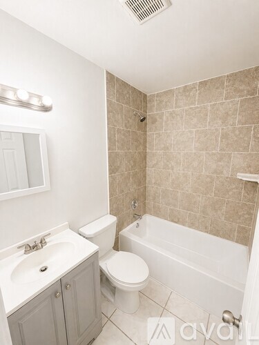 A bathroom with a toilet, sink, and bathtub.