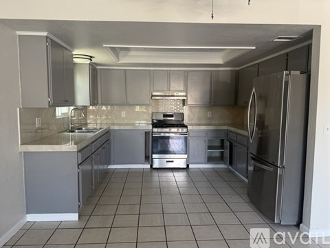 A kitchen with a stove, oven, and refrigerator.