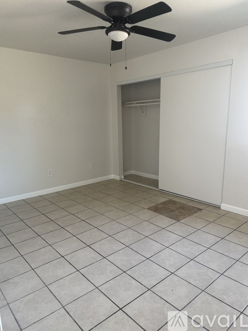 A room with a ceiling fan and tile flooring.