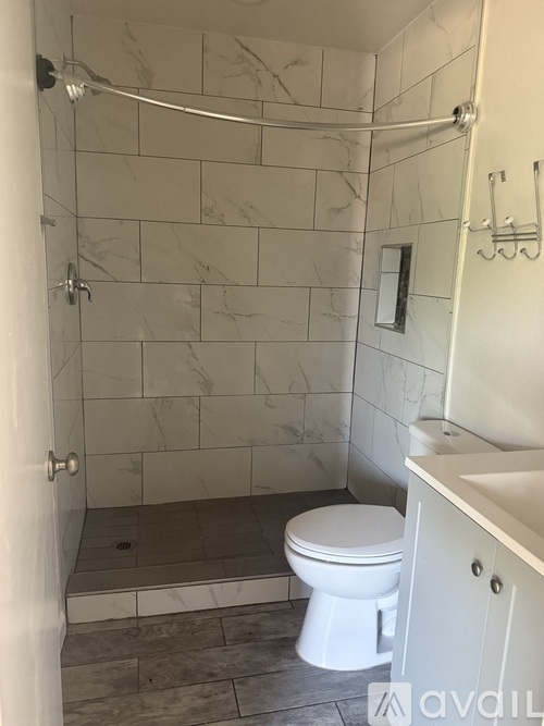 A white toilet in a bathroom with marble tiles.