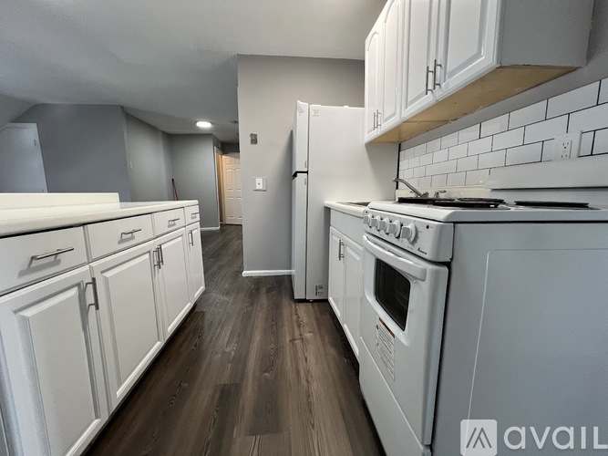 A kitchen with white appliances and cabinets.