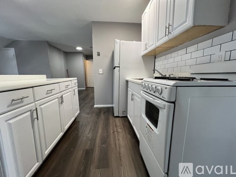 A kitchen with white appliances and cabinets.