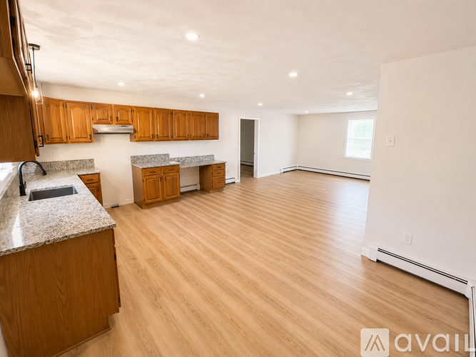 A kitchen with wooden cabinets and a marble countertop.
