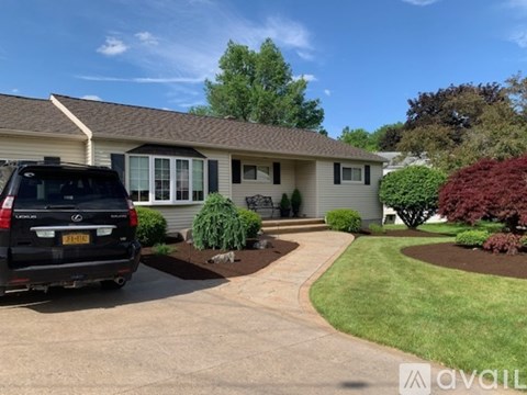 A house with a black SUV parked in front.
