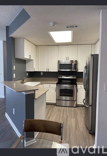 A kitchen with a refrigerator, sink, and oven.
