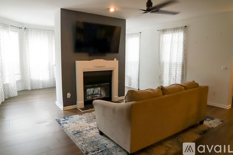 A living room with a fireplace and a television on the wall.