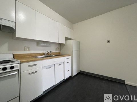 A kitchen with white cabinets and a wooden countertop.