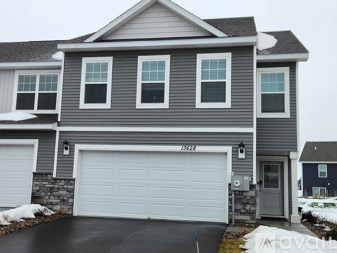 A grey house with a white garage door and a grey door.