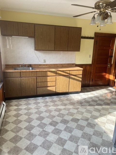 A kitchen with wooden cabinets and a checkered floor.