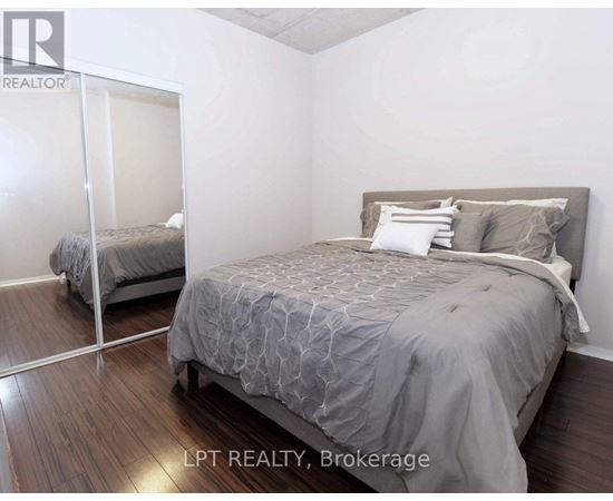 A bedroom with a large bed and a mirror on the wall.