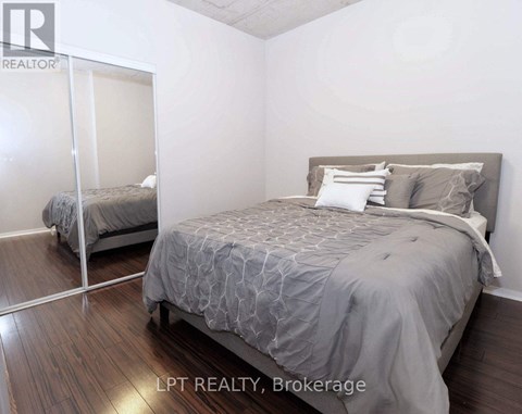 A bedroom with a large bed and a mirror on the wall.