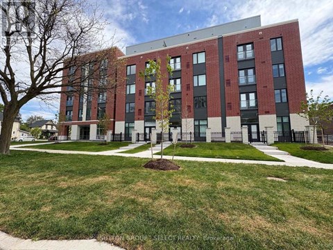 A modern red brick building with a tree in front.
