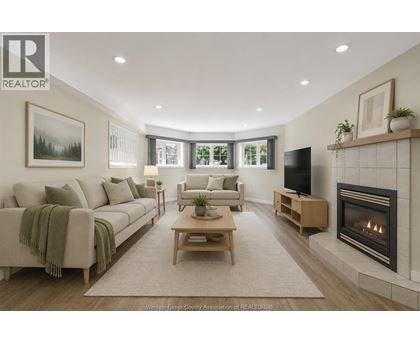 A living room with a couch, a chair, a coffee table, and a fireplace.