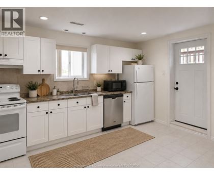 A kitchen with white cabinets and appliances.