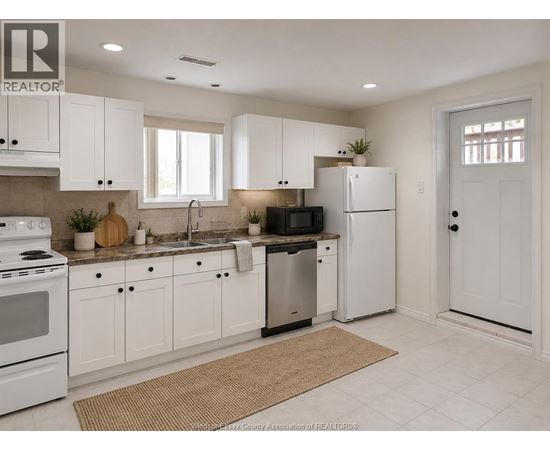 A kitchen with white cabinets and appliances.