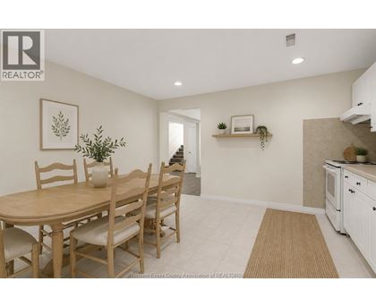 A dining room with a table and chairs.