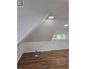 A room with wooden flooring and a window.