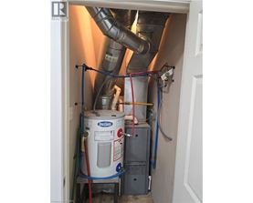 A Spaceshuttle tank is in a doorway with pipes and wires connected to it.