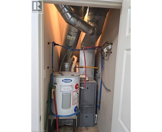 A Spaceshuttle tank is in a doorway with pipes and wires connected to it.