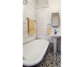 A white bathroom with a black and white floor.