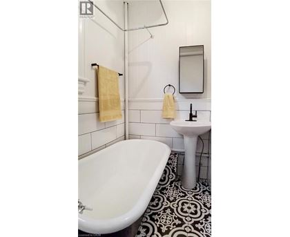 A white bathroom with a black and white floor.